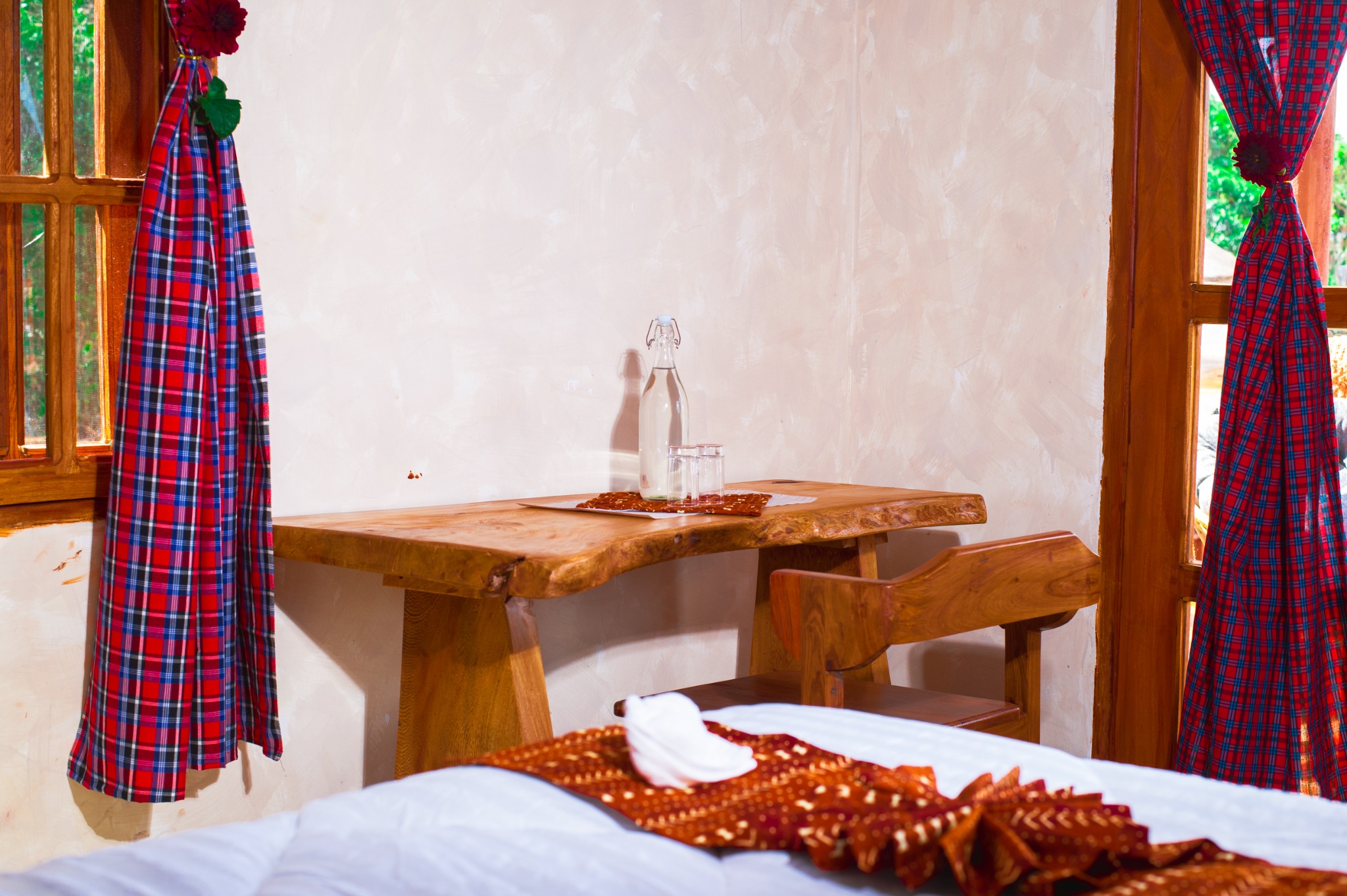 Handmade wooden desk and glass water bottle in a Kutana suite